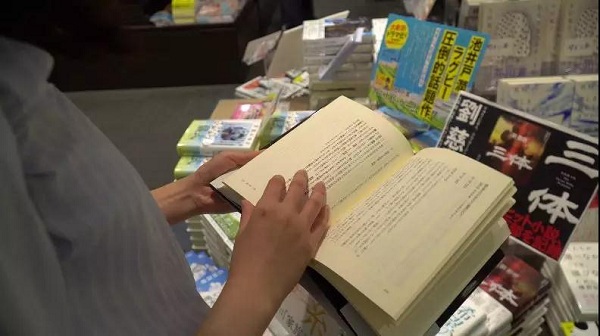 日本读者在书店翻看《三体》日文版一书。来源：视频截图